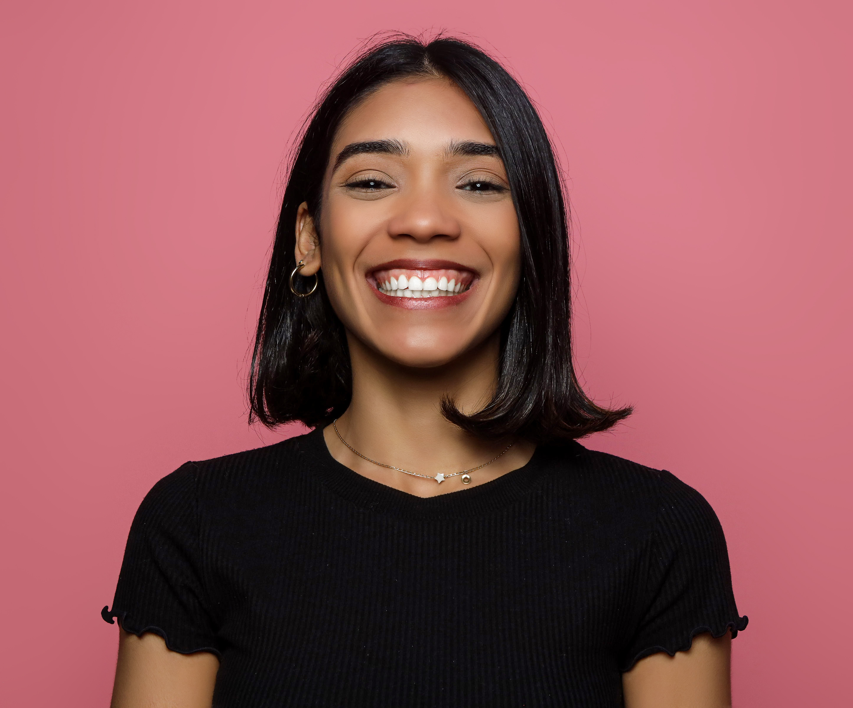 Mujer sonriente con fondo rosa